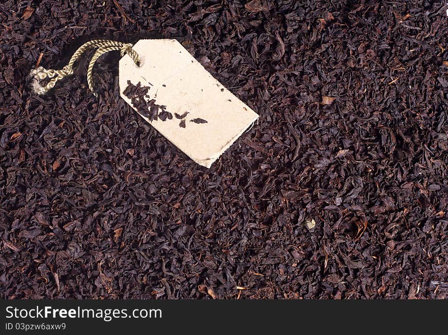 Macro photo of black tea leaves and paper label