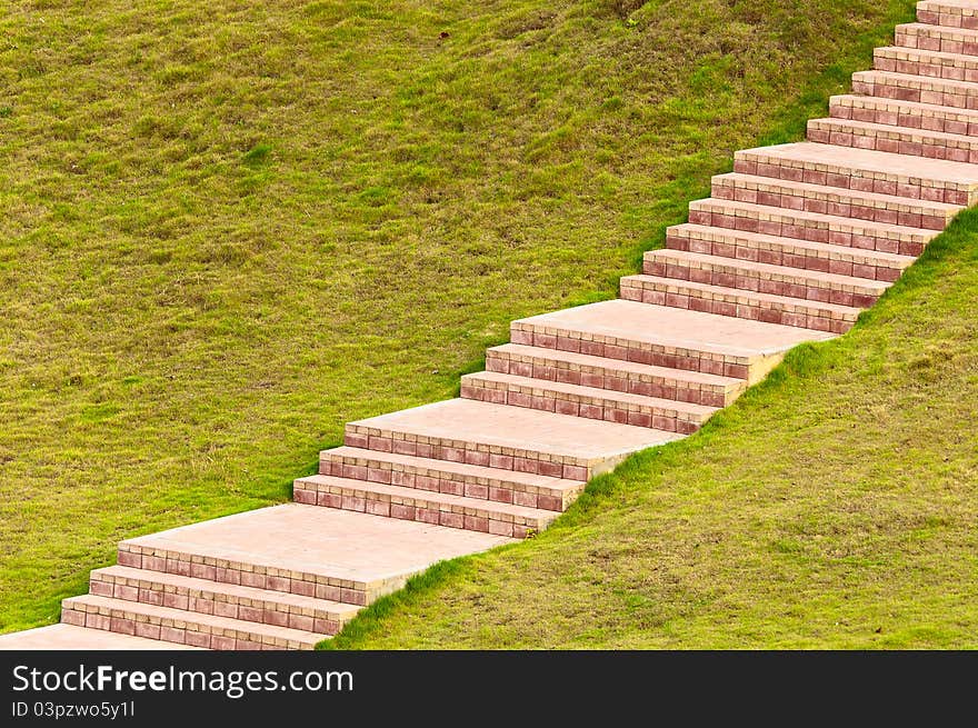 Garden stone path with grass growing up between and around stones, Brick Sidewalk