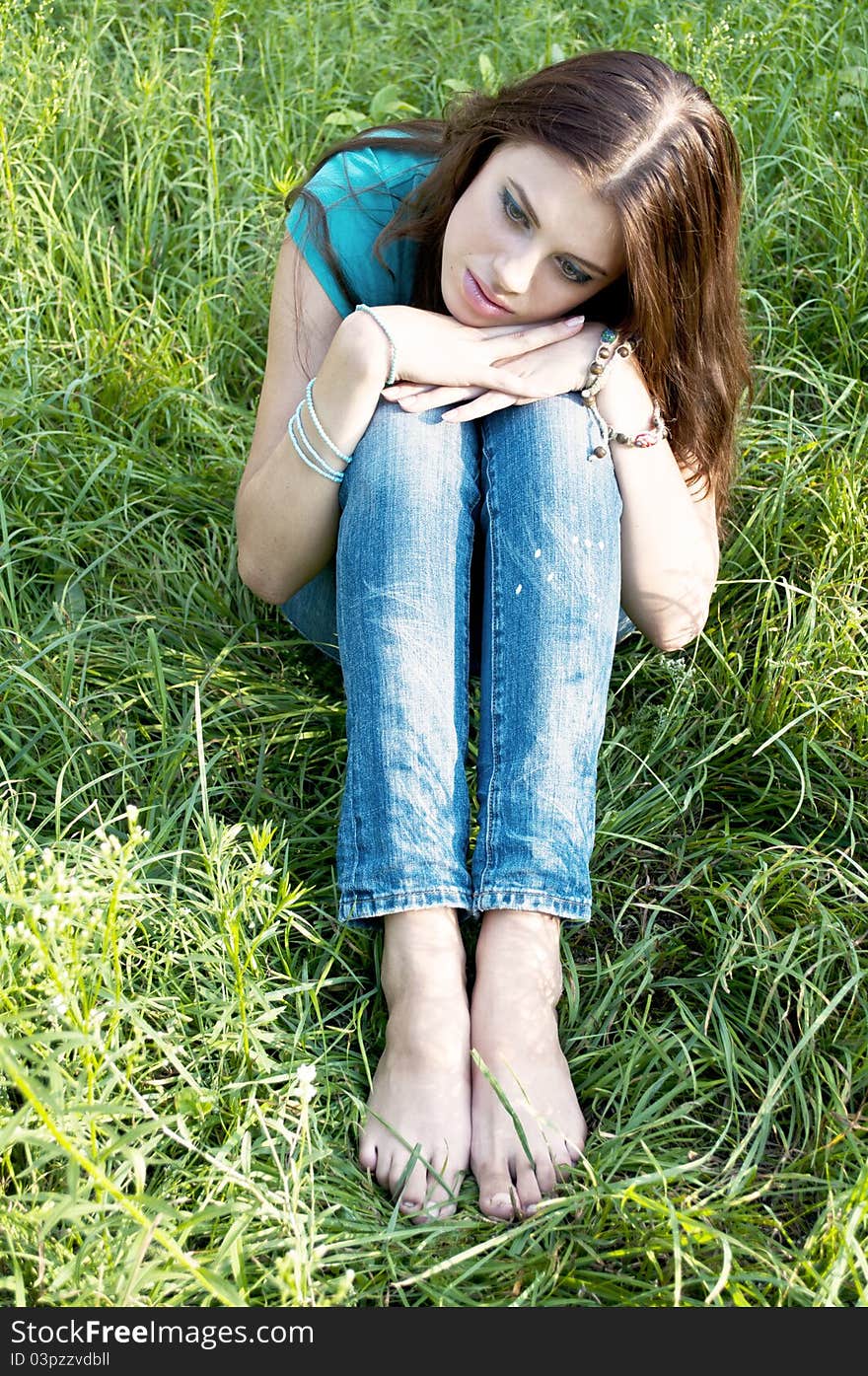 A beautiful girl sitting on grass