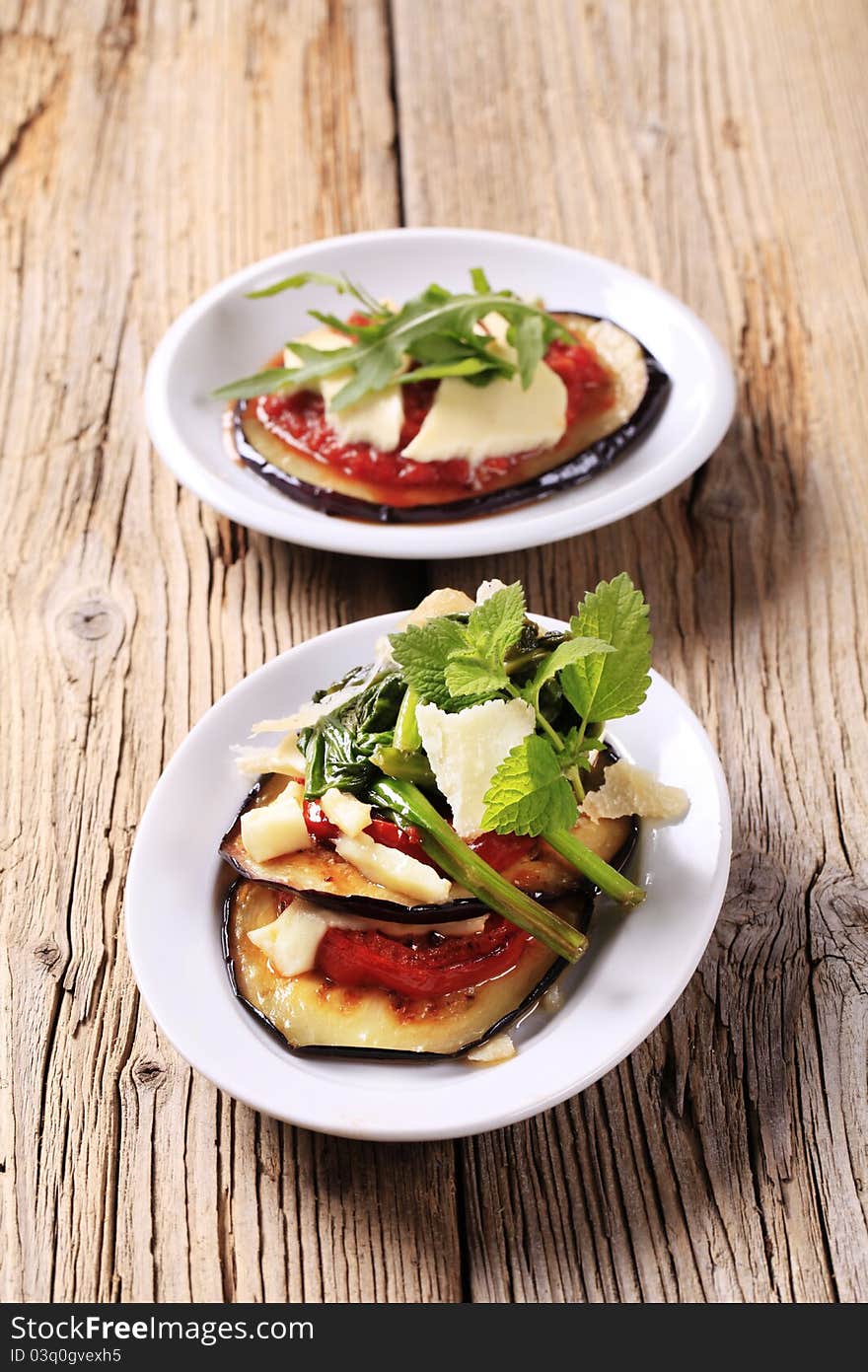 Grilled aubergine and tomato sprinkled with cheese. Grilled aubergine and tomato sprinkled with cheese