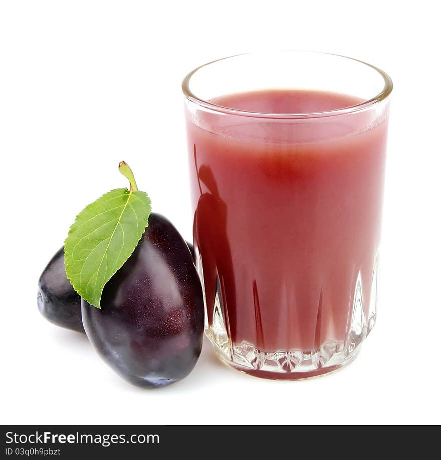 Glass of juice with plums on a white background