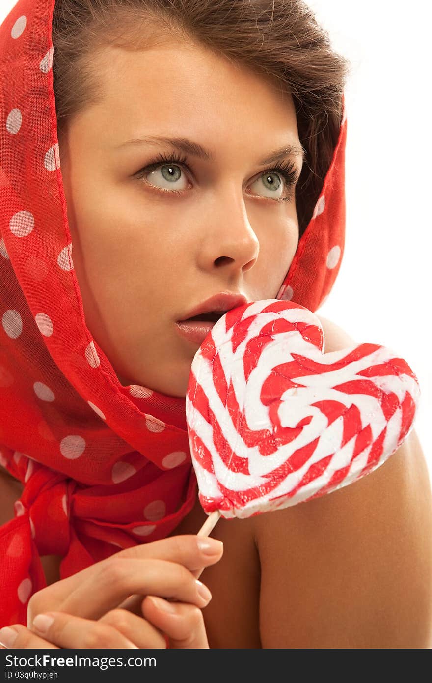 Close-up portrait of young woman with heart shaped lollipop