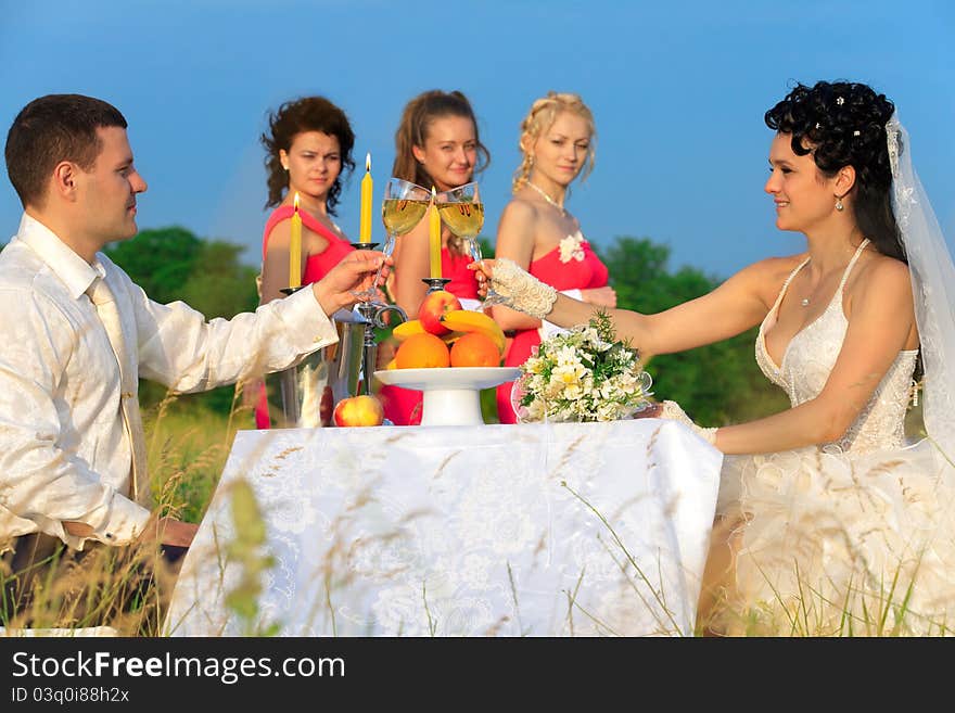 Bride and groom clinking glasses of champagne at wedding table