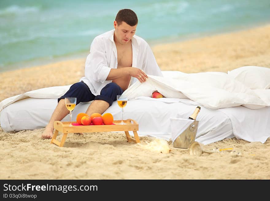 Young man in bed at the coastline