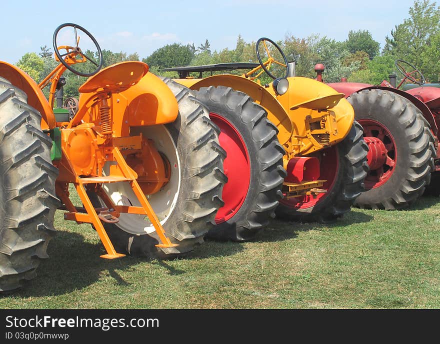 Three Farm Tractors From A Rear View