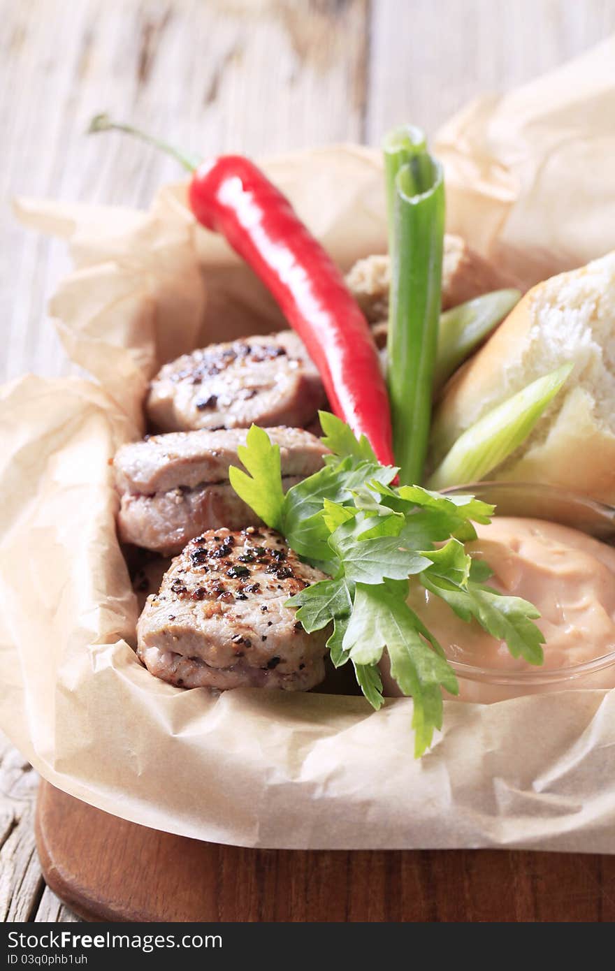 Roast pork tenderloin with bread roll and dipping sauce