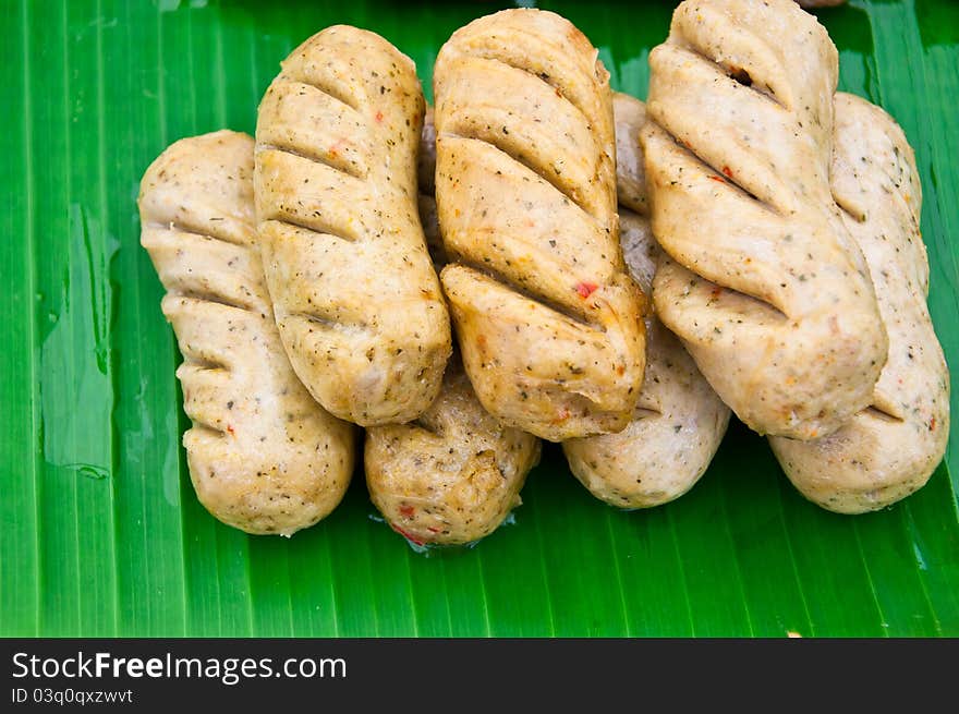 This is fried sausage on banana leaves background. This is fried sausage on banana leaves background