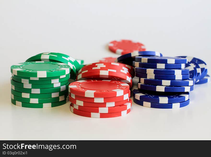 Three short stacks of colorful poker chips.