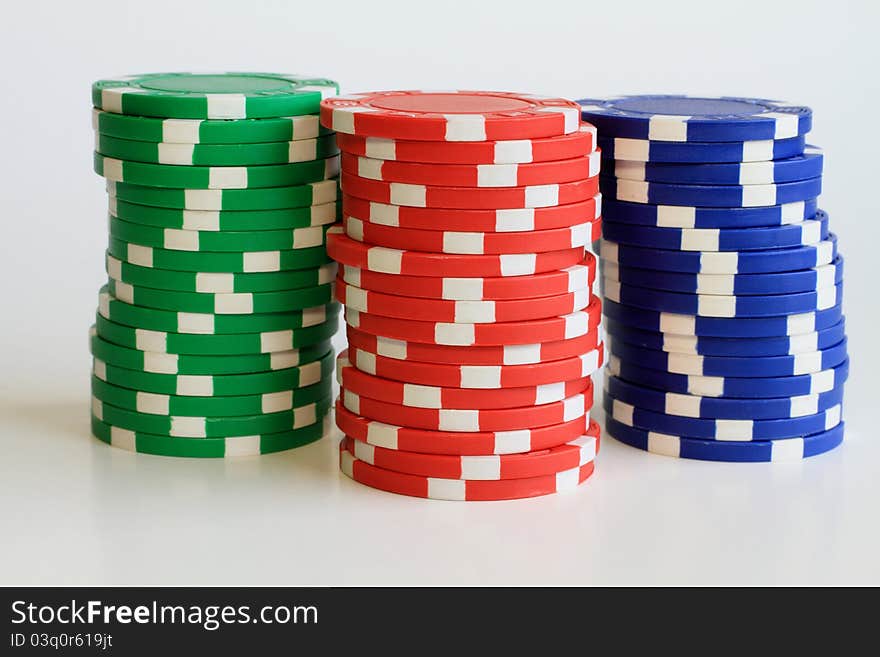 Three tall stacks of colorful poker chips.