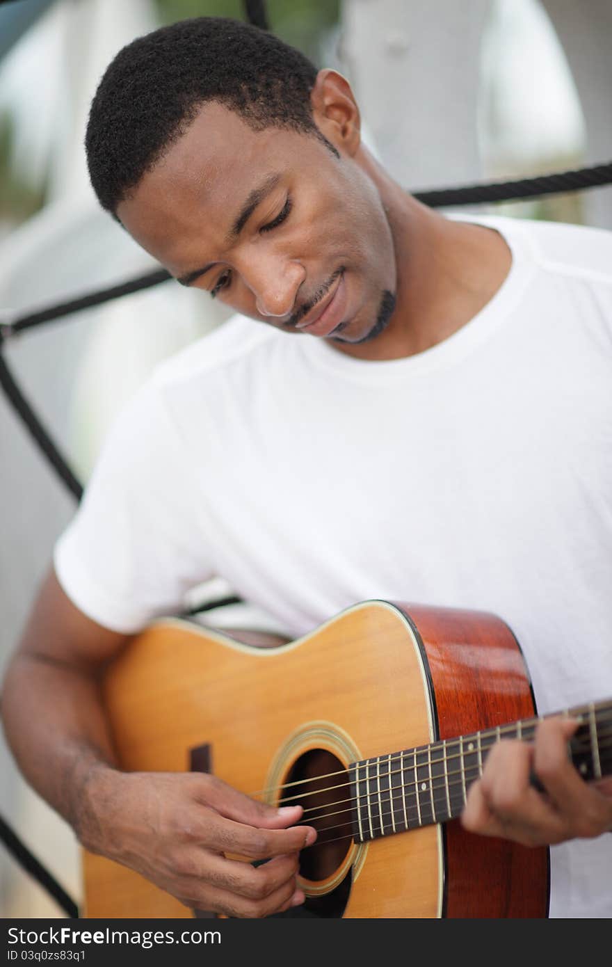 Image of a young black man playing his guitar. Image of a young black man playing his guitar