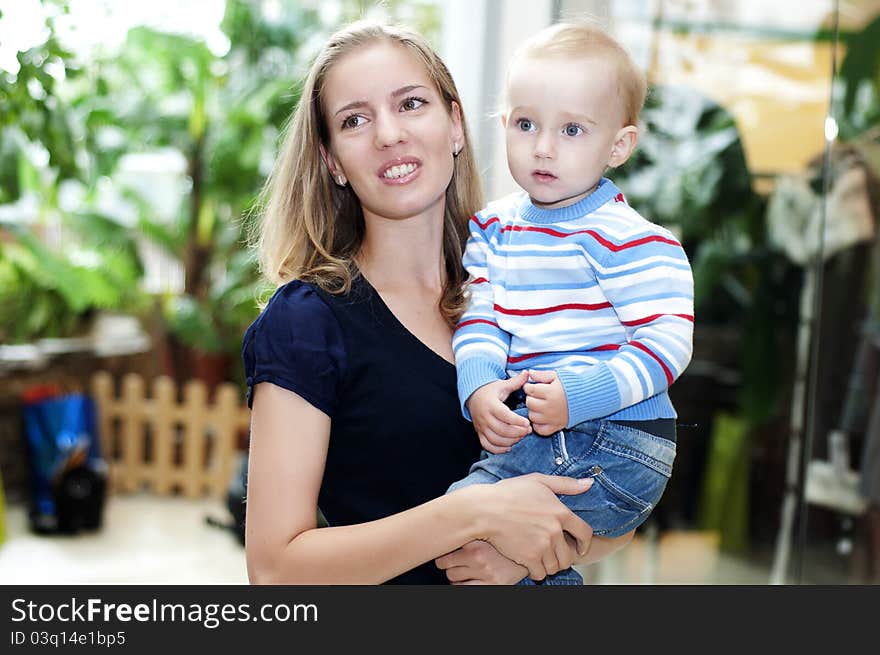 Beautiful women in the store smiling and hugs child. Beautiful women in the store smiling and hugs child