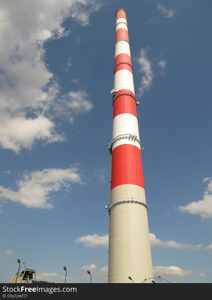 White and red high chimney against a blue sky