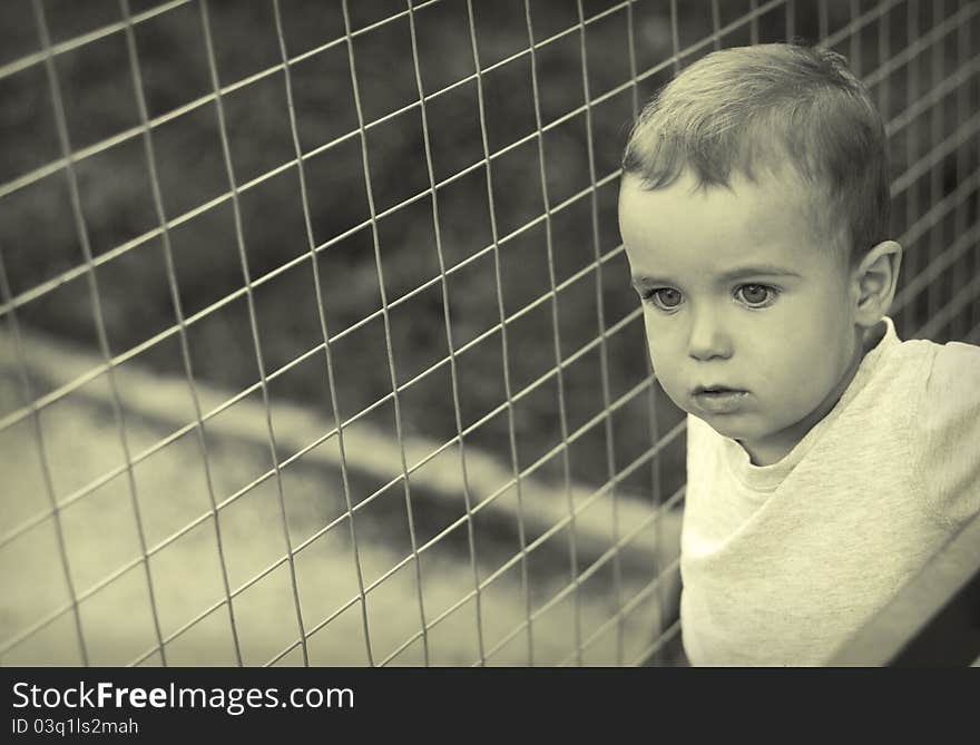 Urban child against the background of metal mesh. Urban child against the background of metal mesh