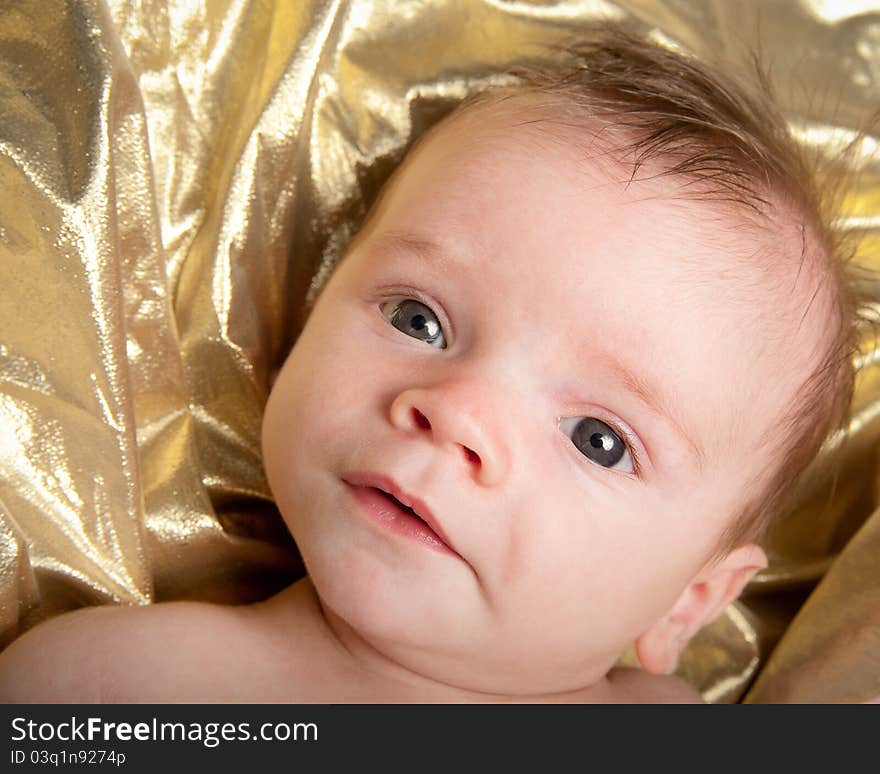 Closeup portrait of baby boy on gold background