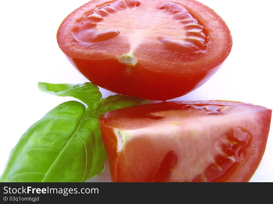 Red tomatoes with green basil on white background