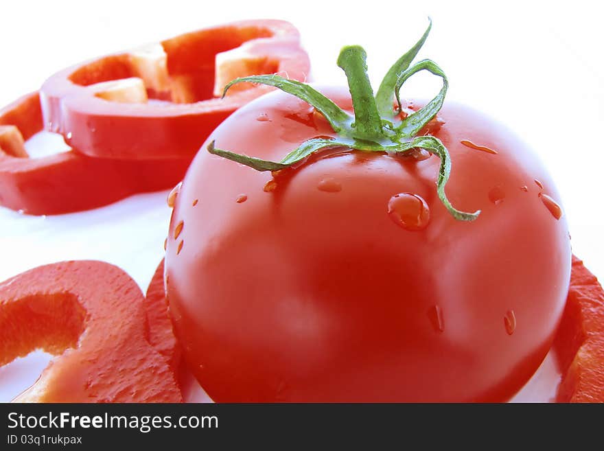 Red tomato and sliced red pepper in background