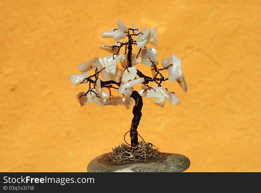 Tree made from metal and shells on orange background. Tree made from metal and shells on orange background