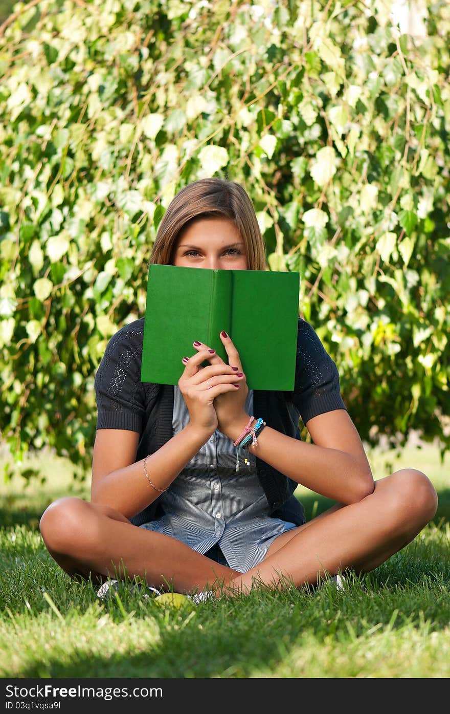 Portrait of a young female student with book at the campus