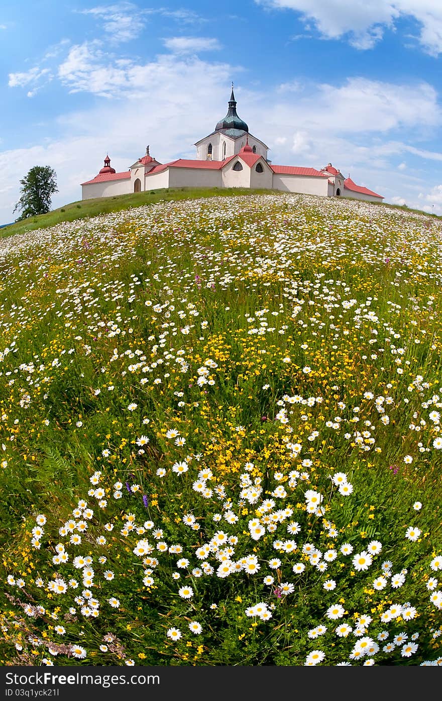 Baroque monastery above the meadow with daisy flowers. Baroque monastery above the meadow with daisy flowers