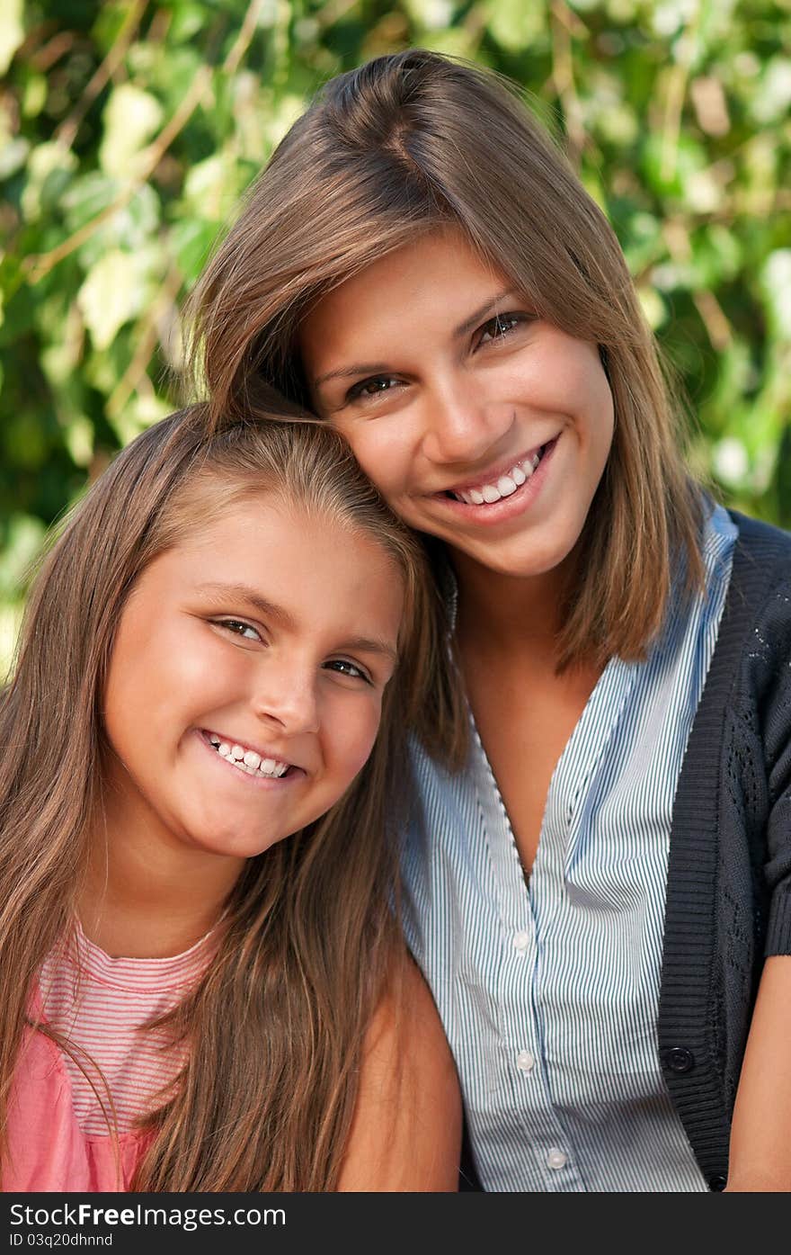 Portrait of happy two sisters in park outdoors. Portrait of happy two sisters in park outdoors