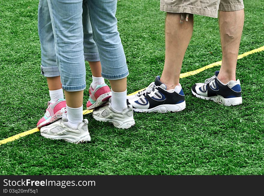 Feet of a family in game, shown as happy family enjoy game or holiday on grass land.