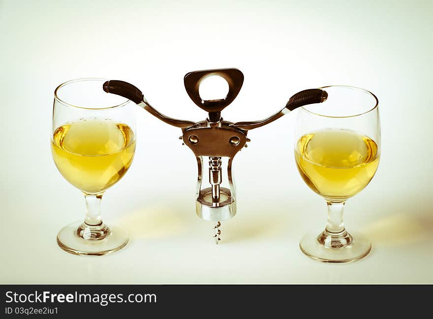 Glass of white wine and corkscrew isolated on a white background. Glass of white wine and corkscrew isolated on a white background