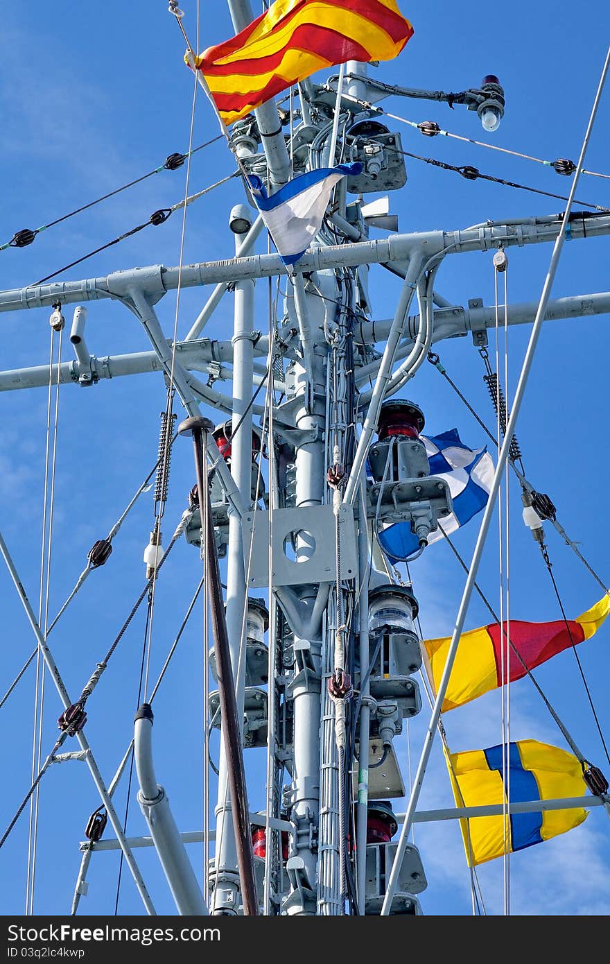 Frigate with signal flags against the blue sky