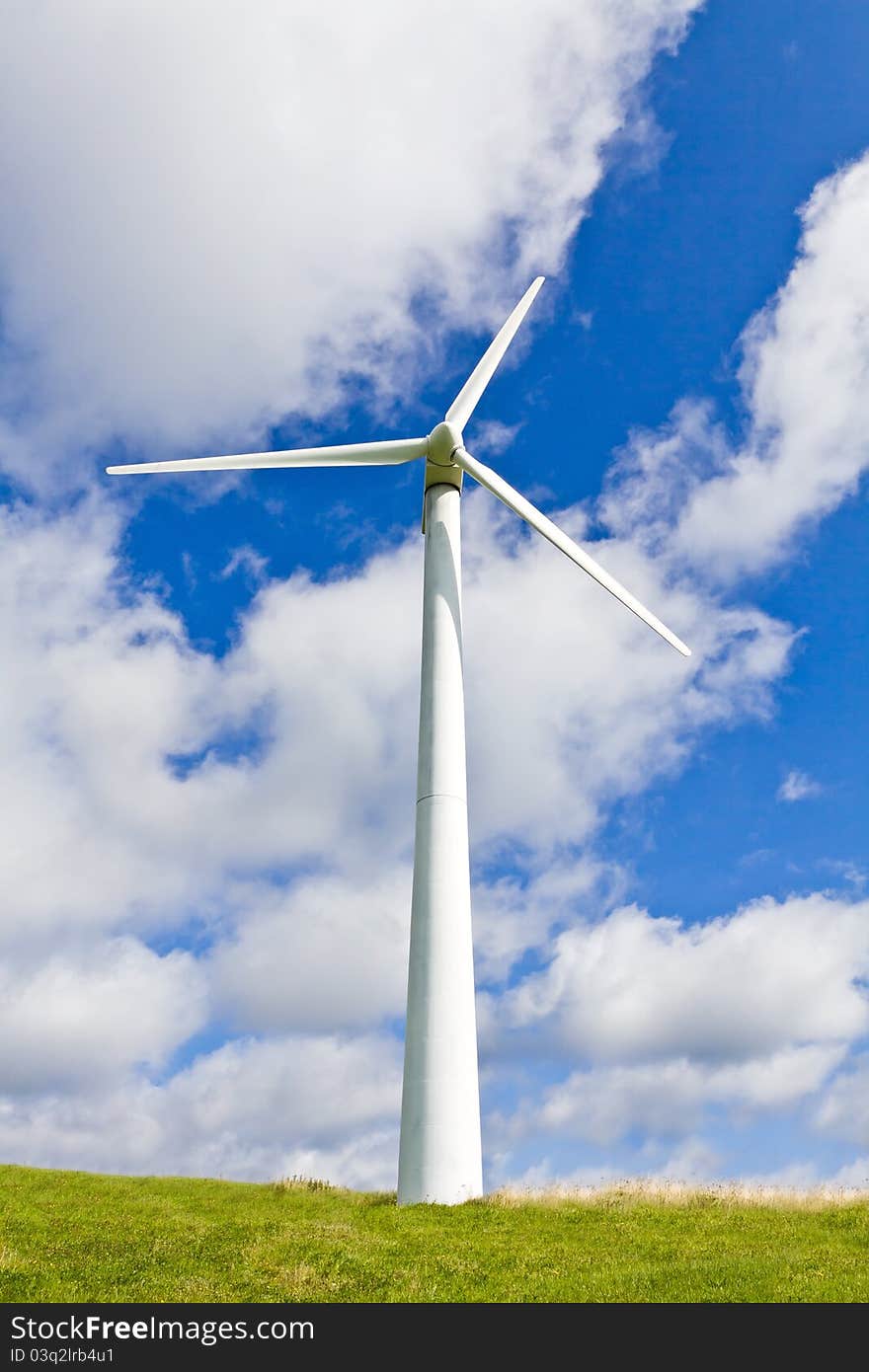 Wind turbine on meadow and blue sky. Wind turbine on meadow and blue sky