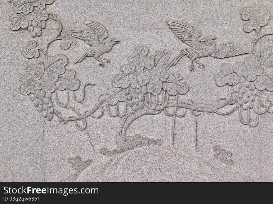 Bird carved on stone wall in chinese temple Thailand