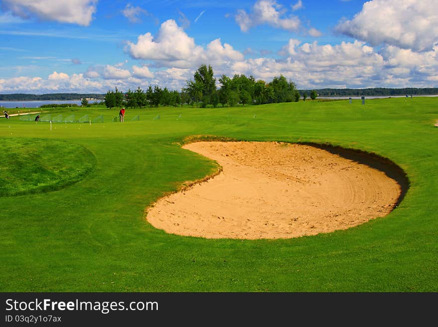 Sand course with green grass and blue sky. Sand course with green grass and blue sky