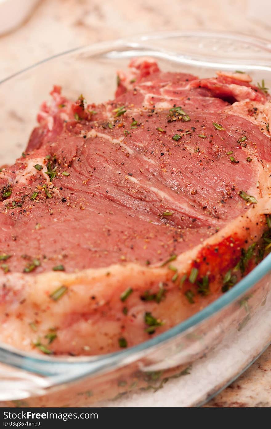 Delicious prime rib marinated with herbs and spices ready to be cooked. Delicious prime rib marinated with herbs and spices ready to be cooked