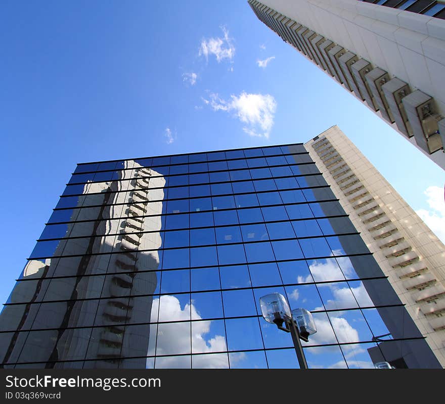 Office building with a facade from glass, skyscraper reflection in windows. Office building with a facade from glass, skyscraper reflection in windows.