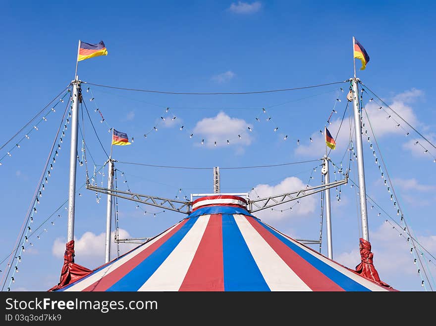 A circus tent with a blue sky in the background