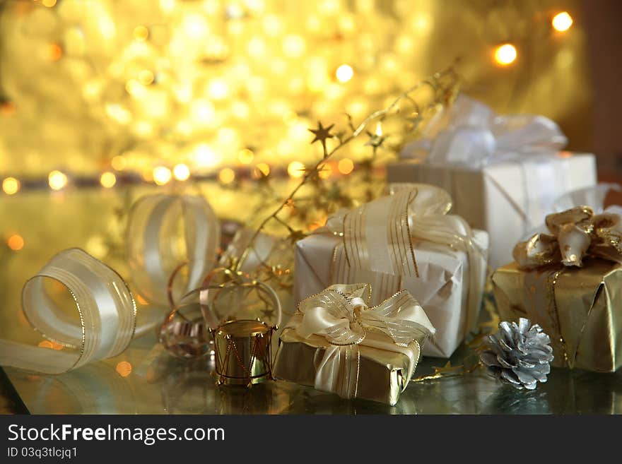 Close-up of gift boxes and twinkle lights on golden background. Close-up of gift boxes and twinkle lights on golden background