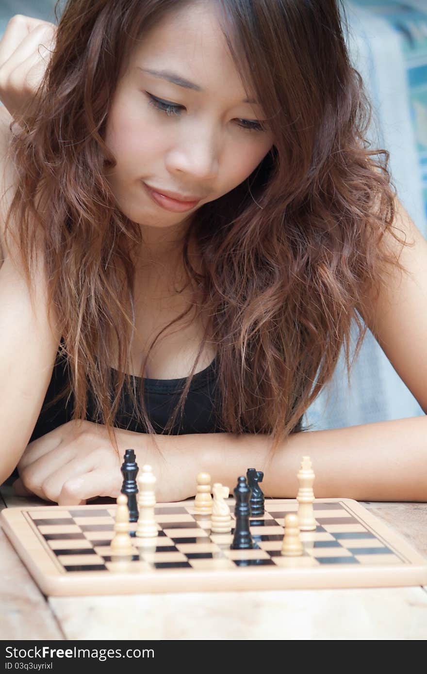 Asian woman playing chess at outdoor