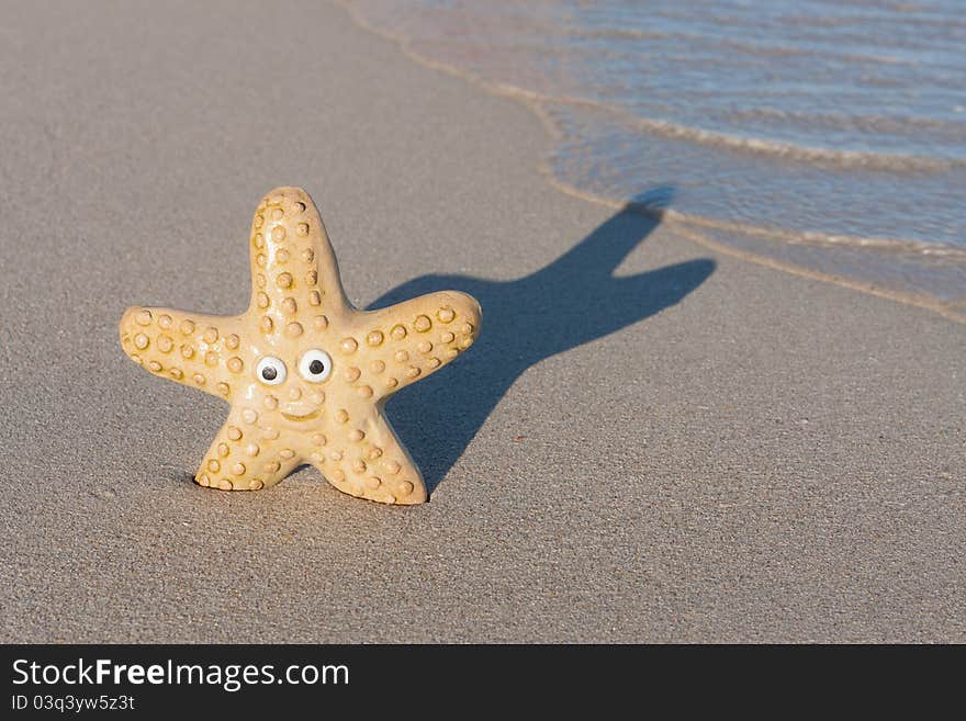 Smiling starfish with victory sign on the beach