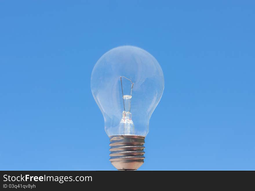 Single light bulb in blue sky. Single light bulb in blue sky