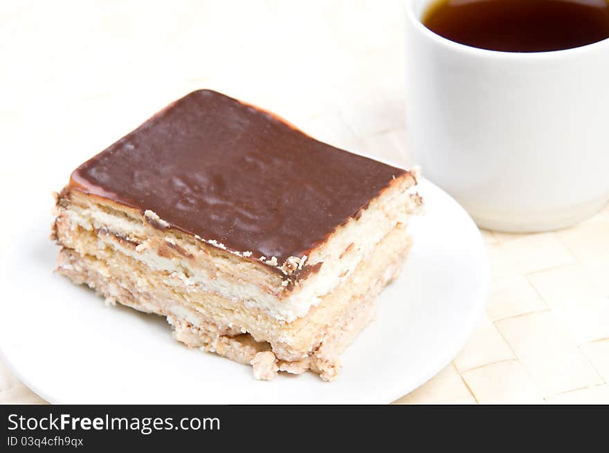 Handmade cake on plate with cup of tea