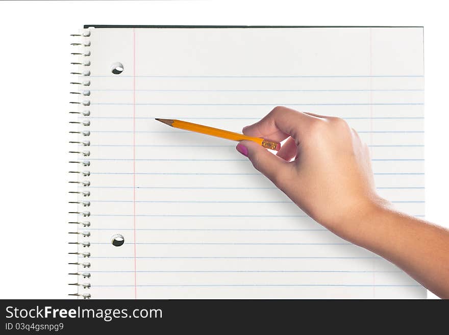 A hand holding a pencil over a blank page in a notebook. A hand holding a pencil over a blank page in a notebook