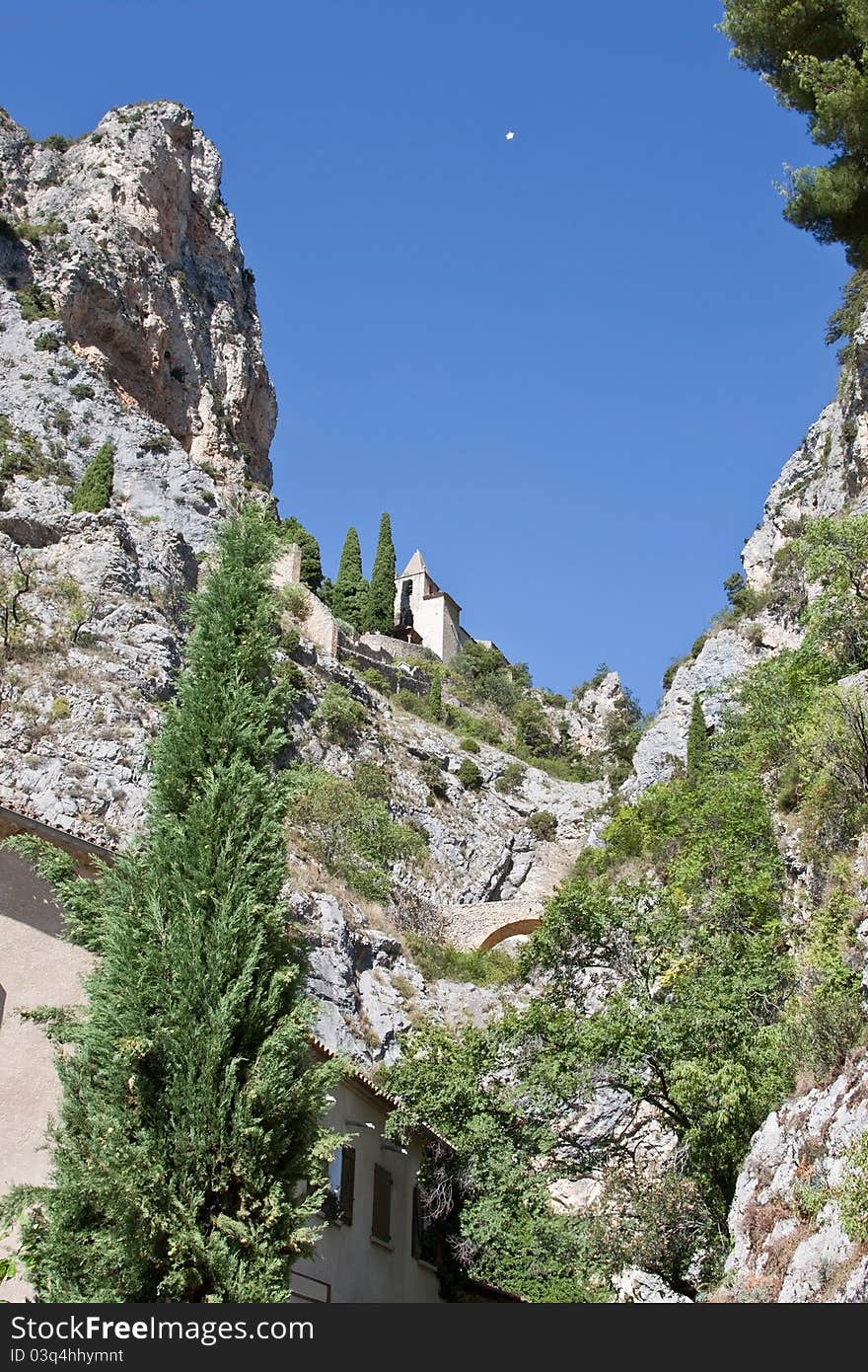 The mountain chapel at Moustier Sainte Marie, France with its star suspended between the cliffs