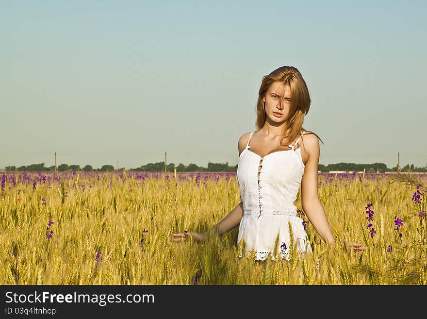 A beautiful woman walks across the field. A beautiful woman walks across the field