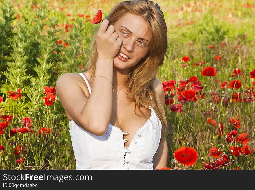 Portrait of a beautiful girl in the red poppies