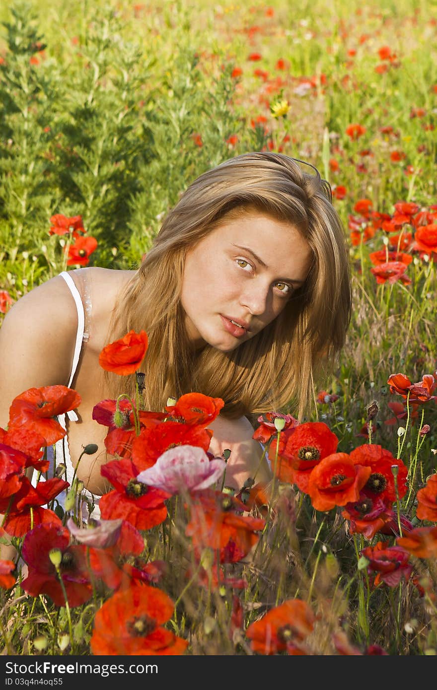 Portrait of a beautiful girl in the red poppies