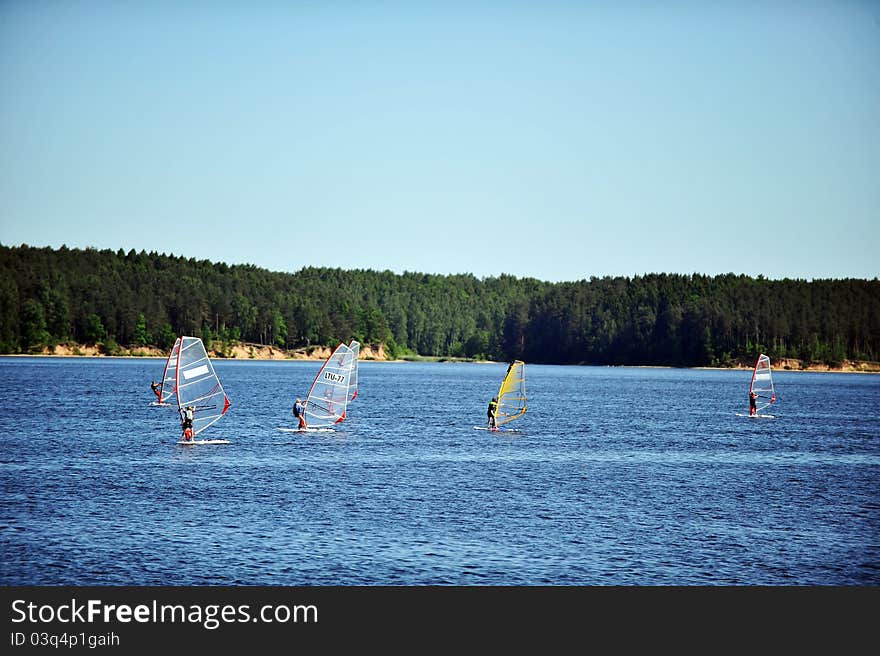 Five windsurfers on blue sea. summer day. Five windsurfers on blue sea. summer day