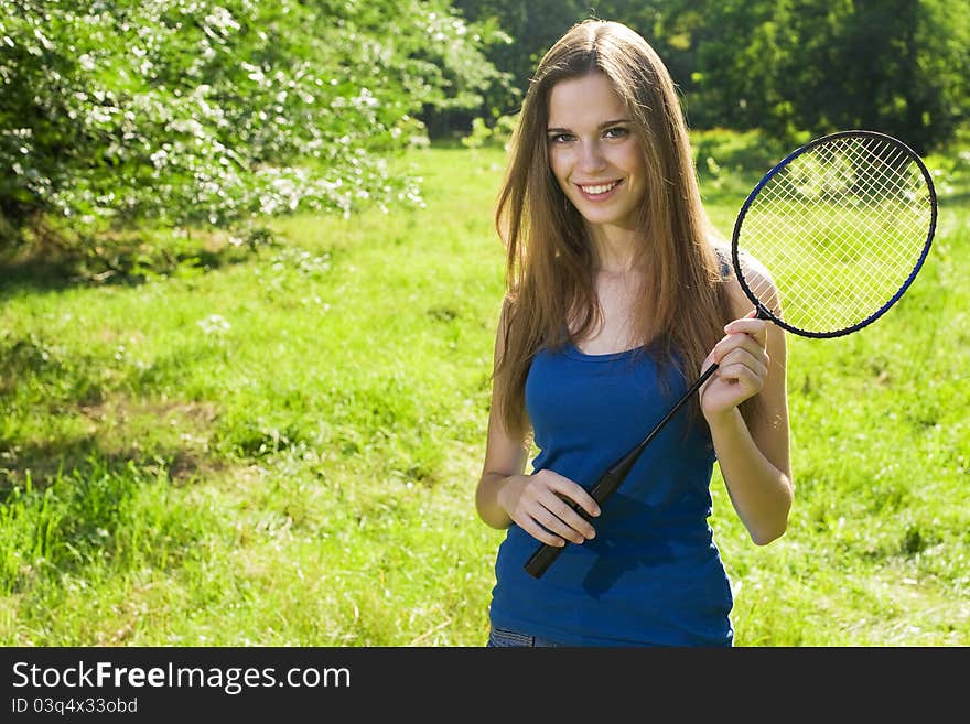 Female tennis player with a racket outdoors