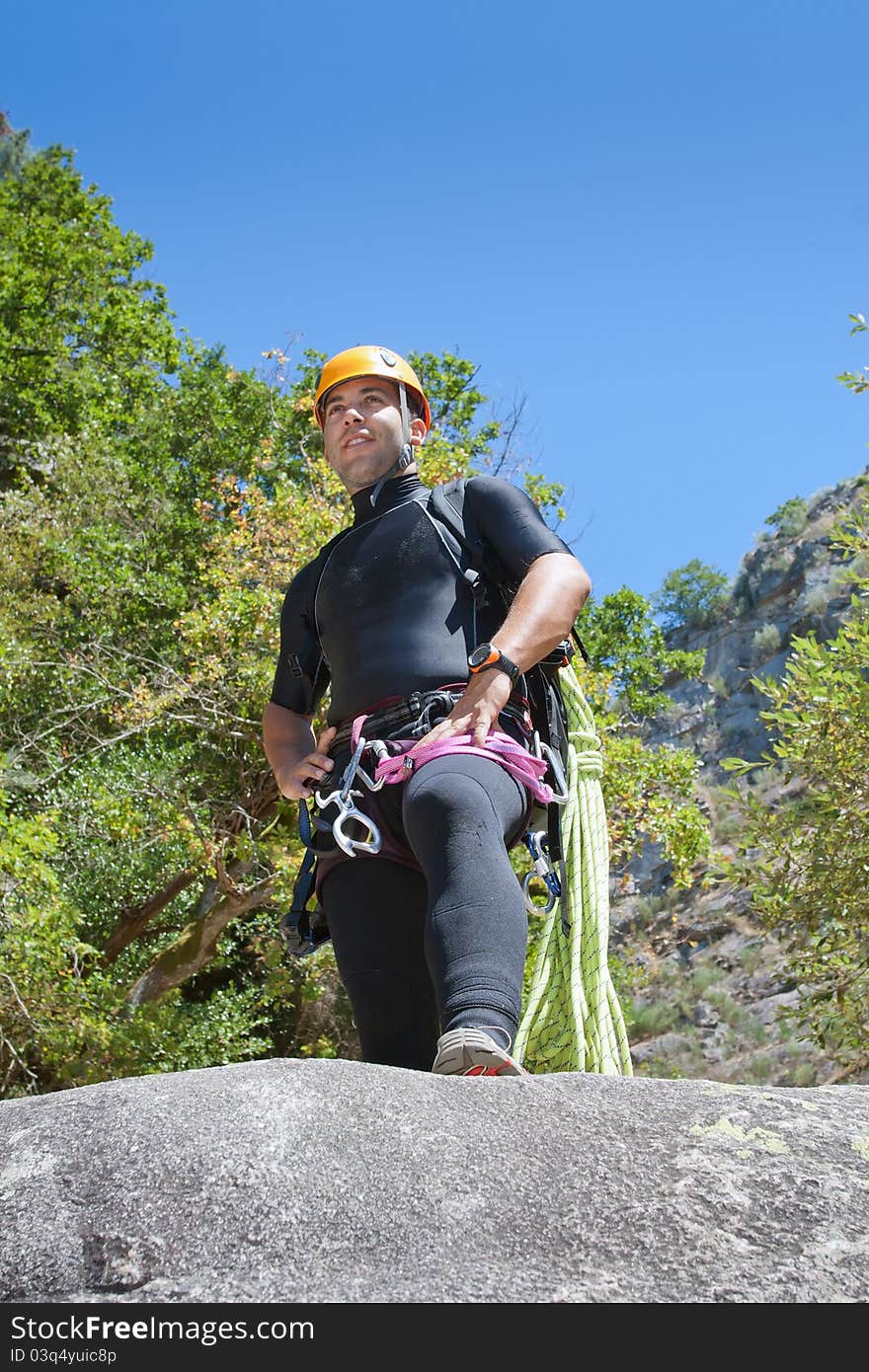 Men staring into horizont and prepering to rappeling into a canyon. Men staring into horizont and prepering to rappeling into a canyon