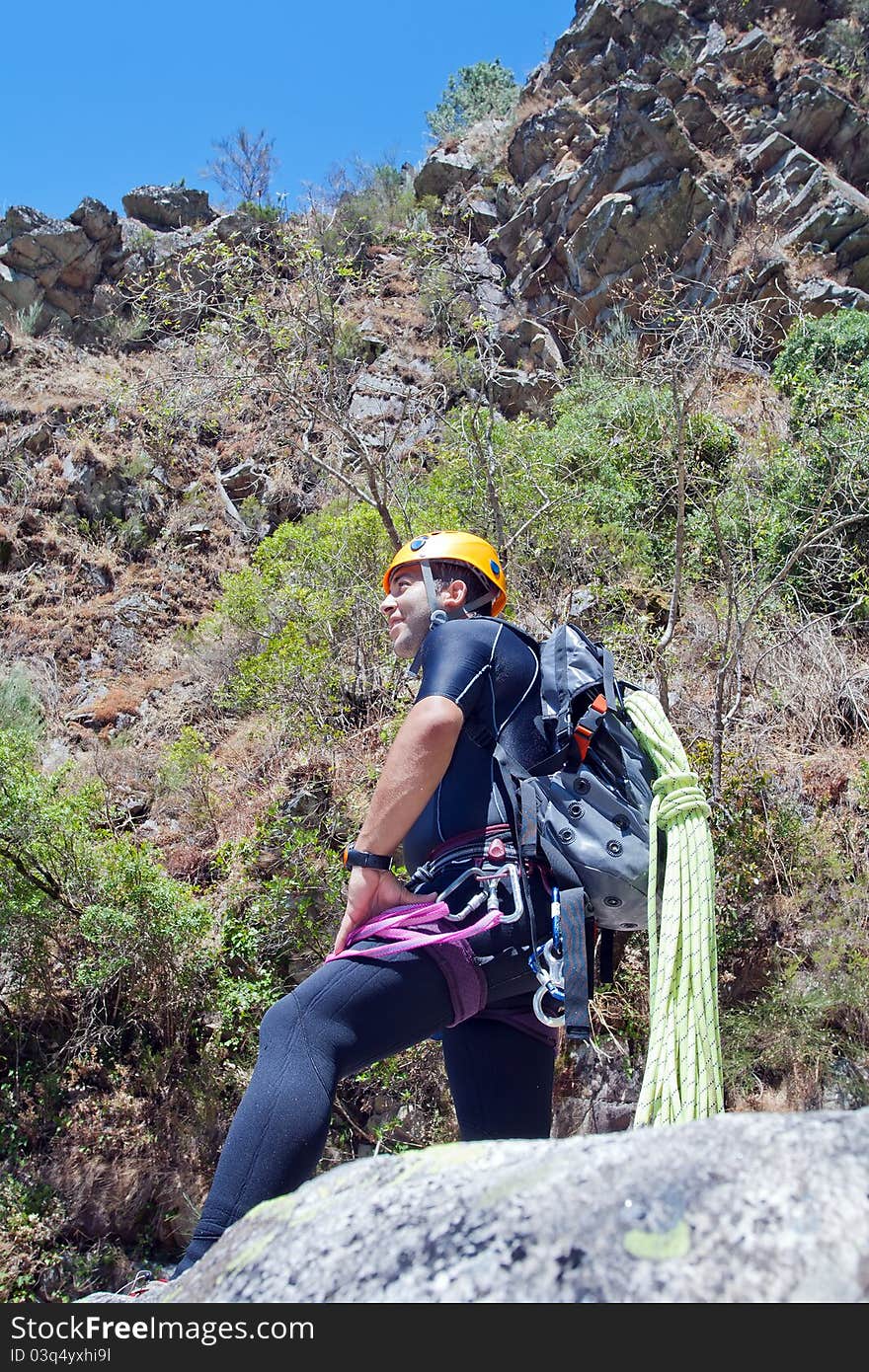 Men staring into horizont and prepering to rappeling into a canyon. Men staring into horizont and prepering to rappeling into a canyon