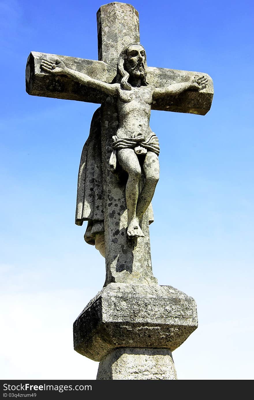 Old cross, and Christ in blue sky.