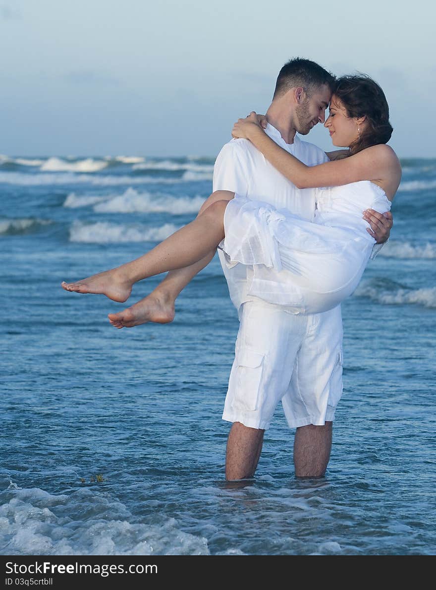 Man holding women in his arms on beach. Man holding women in his arms on beach