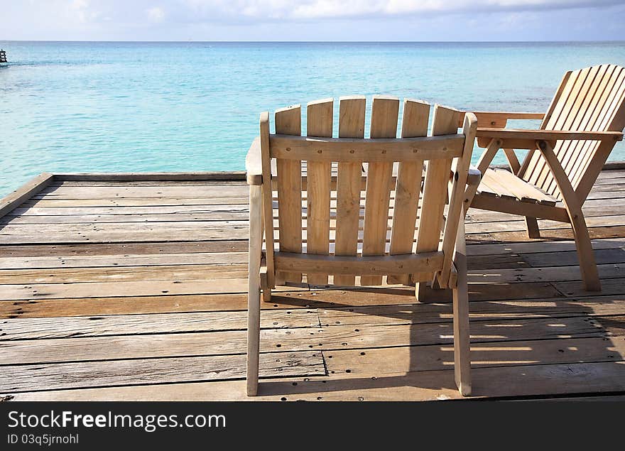 Sunlounges on a wooden deck overlooking the Indian Ocean in the Maldives. Sunlounges on a wooden deck overlooking the Indian Ocean in the Maldives